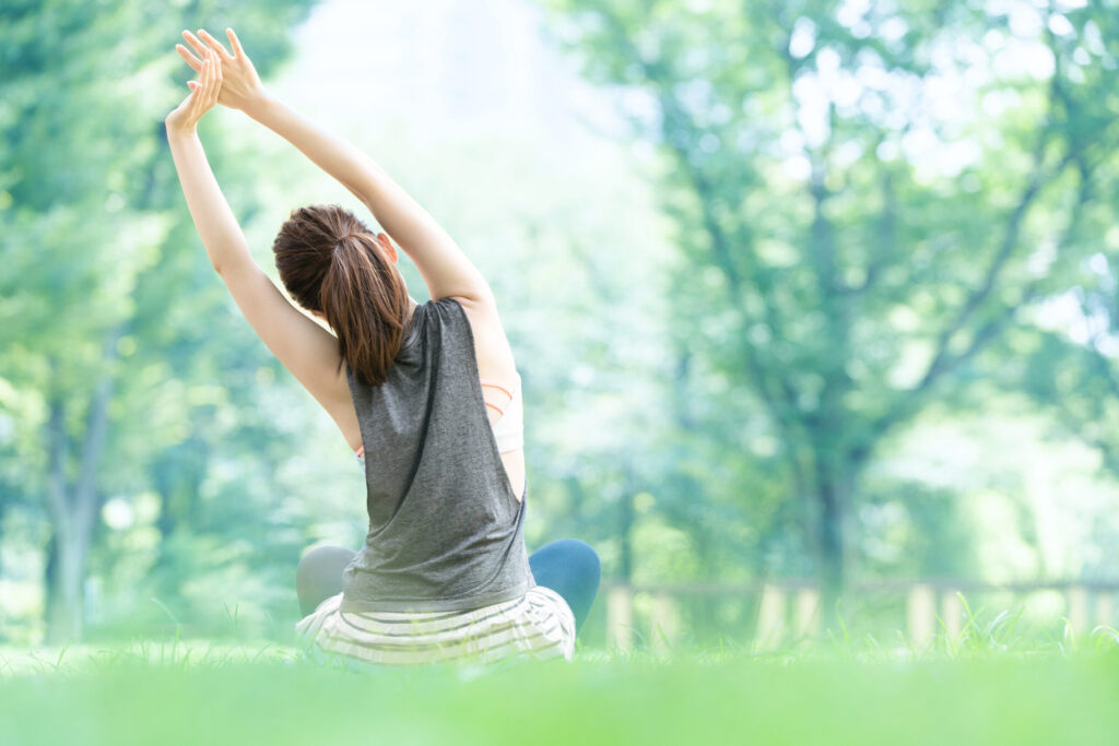 公園でヨガ・ストレッチをする女性